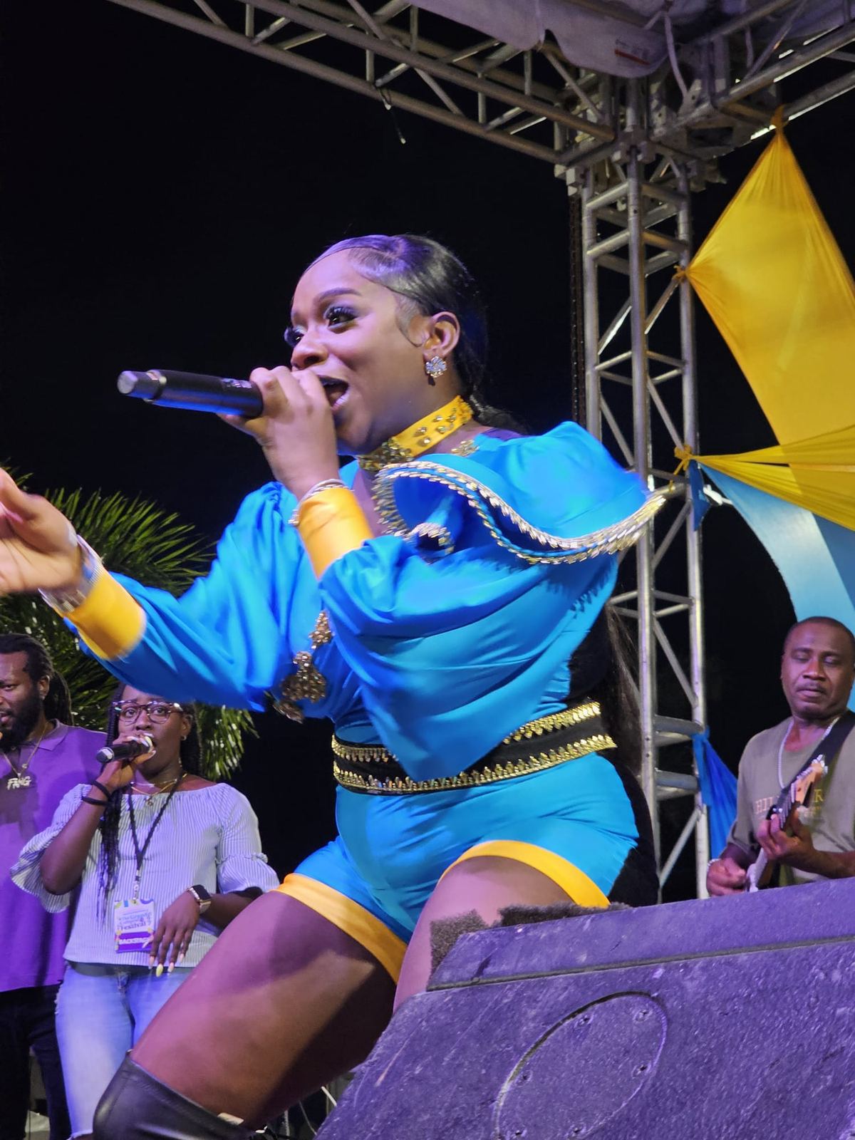 Mama D singing at the Grand Bahama Cultural Festival in a blue and gold outfit