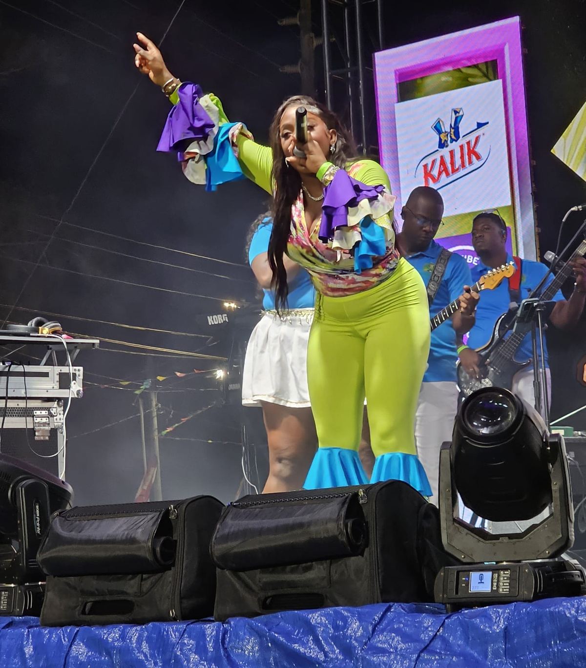 Wide shot of Mama D and her band on a fully lit festival stage