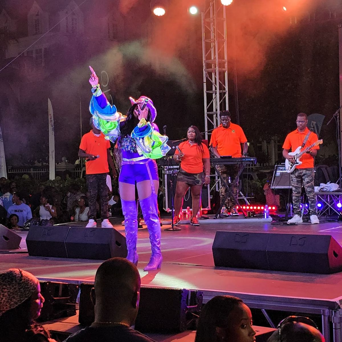 Mama D reaching skyward on stage with her full band behind her